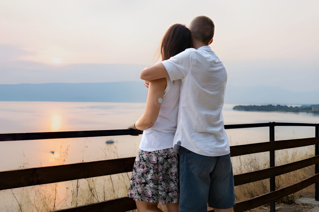 romantic couple is enjoying sunset from high viewpoint they are in love watching the sunset